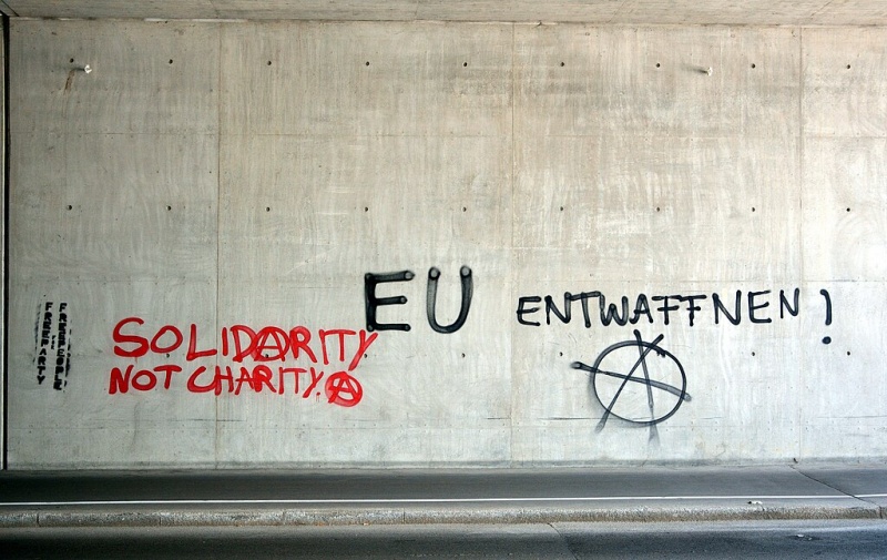 Graffiti in the subway, underground in Vienna’s Favoriten district: ‘Solidarity not charity’ and ‘EU disarm!’ Photo by Herzi Pinki on Wikimedia Commons (CC BY-SA 4.0).